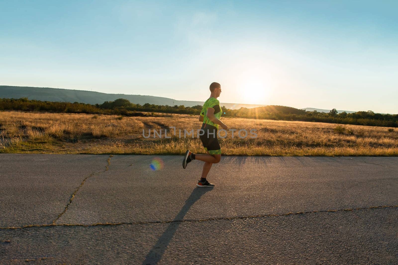 Triathlete in professional gear running early in the morning, preparing for a marathon, dedication to sport and readiness to take on the challenges of a marathon. by dotshock