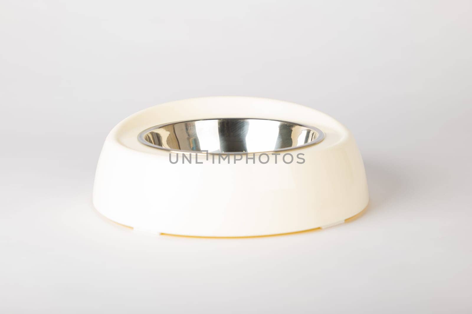 An isolated pet bowl for cat and dog on a clean white background. This circular, metallic tray in a sleek design is perfect for serving their meals and water, promoting animal care.