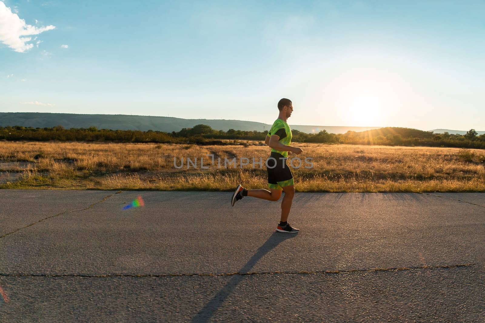 Triathlete in professional gear running early in the morning, preparing for a marathon, dedication to sport and readiness to take on the challenges of a marathon. by dotshock