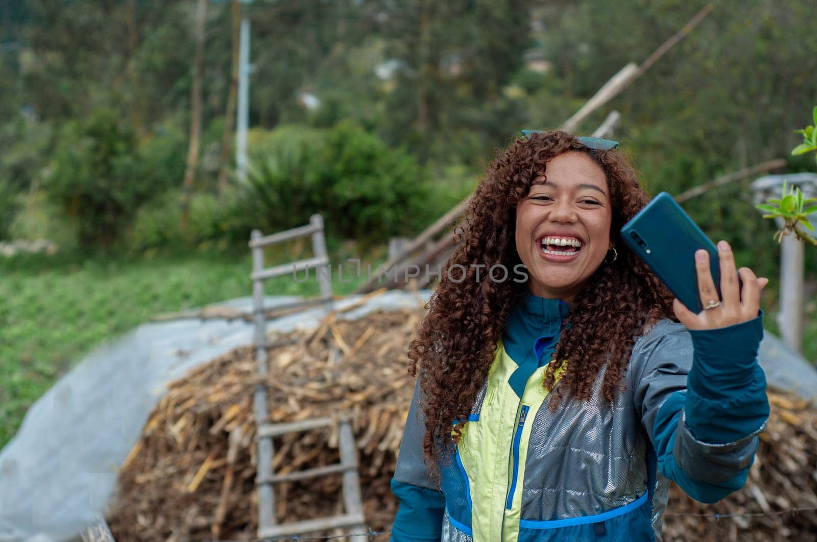 young girl from ecuador very smiling showing her followers a rural house with straw and a ladder made of wood. High quality photo