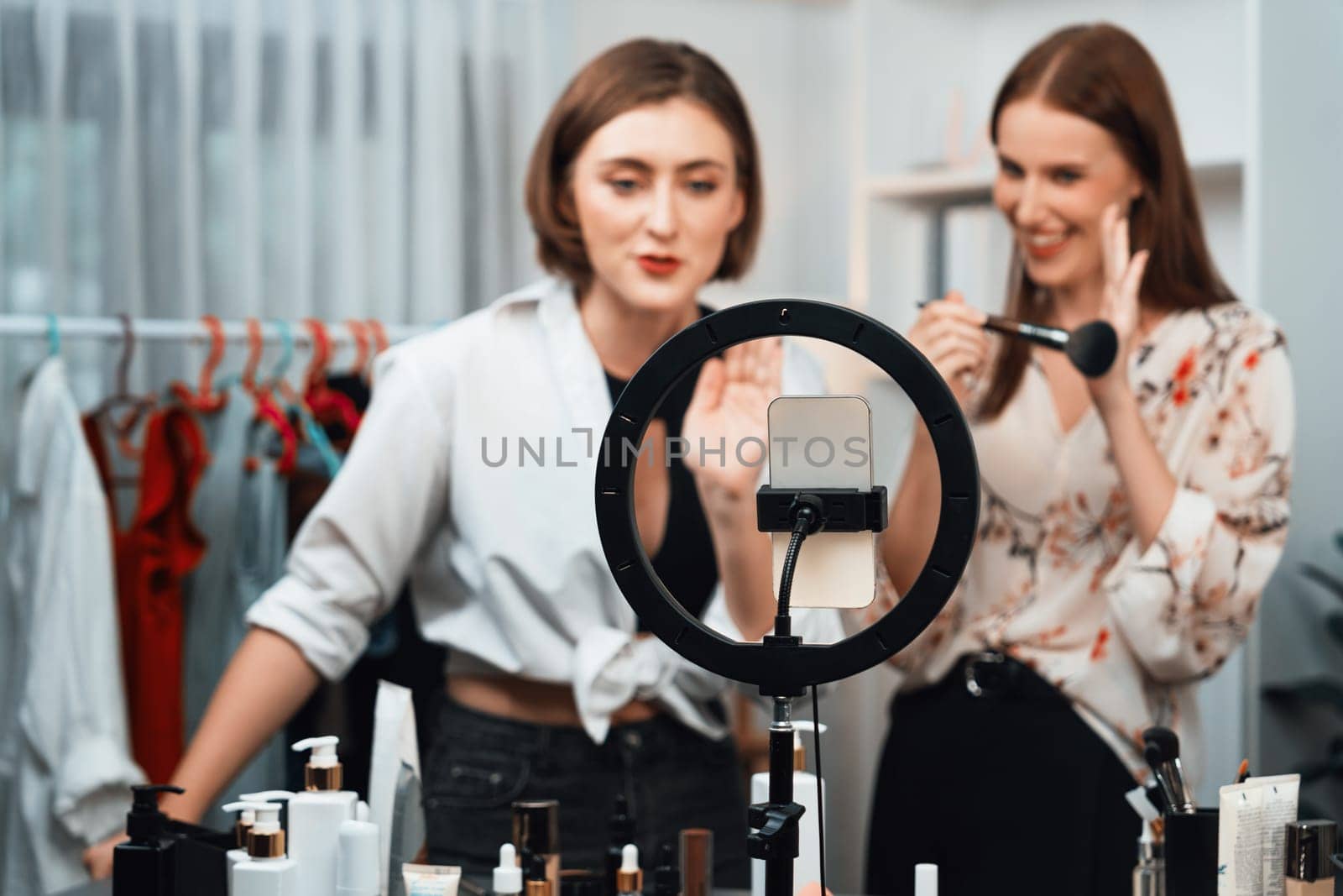 Woman influencer shoot live streaming vlog video review makeup utmost social media or blog. Happy young girl with cosmetics studio lighting for marketing recording session broadcasting online.