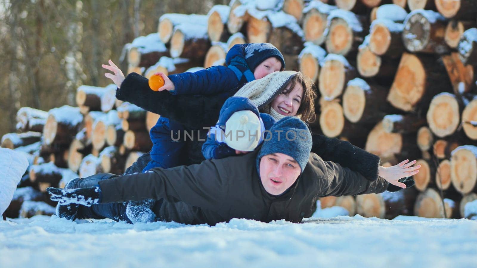 A happy family lying in the snow on a winter's day
