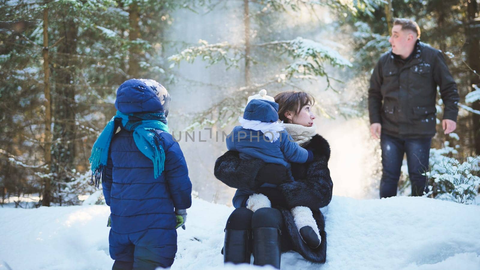 A happy family enjoying a winter sunny day in the woods