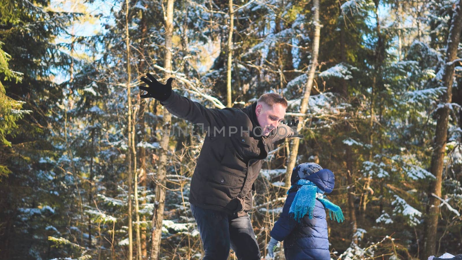 A happy father drops his son off in the winter in the woods