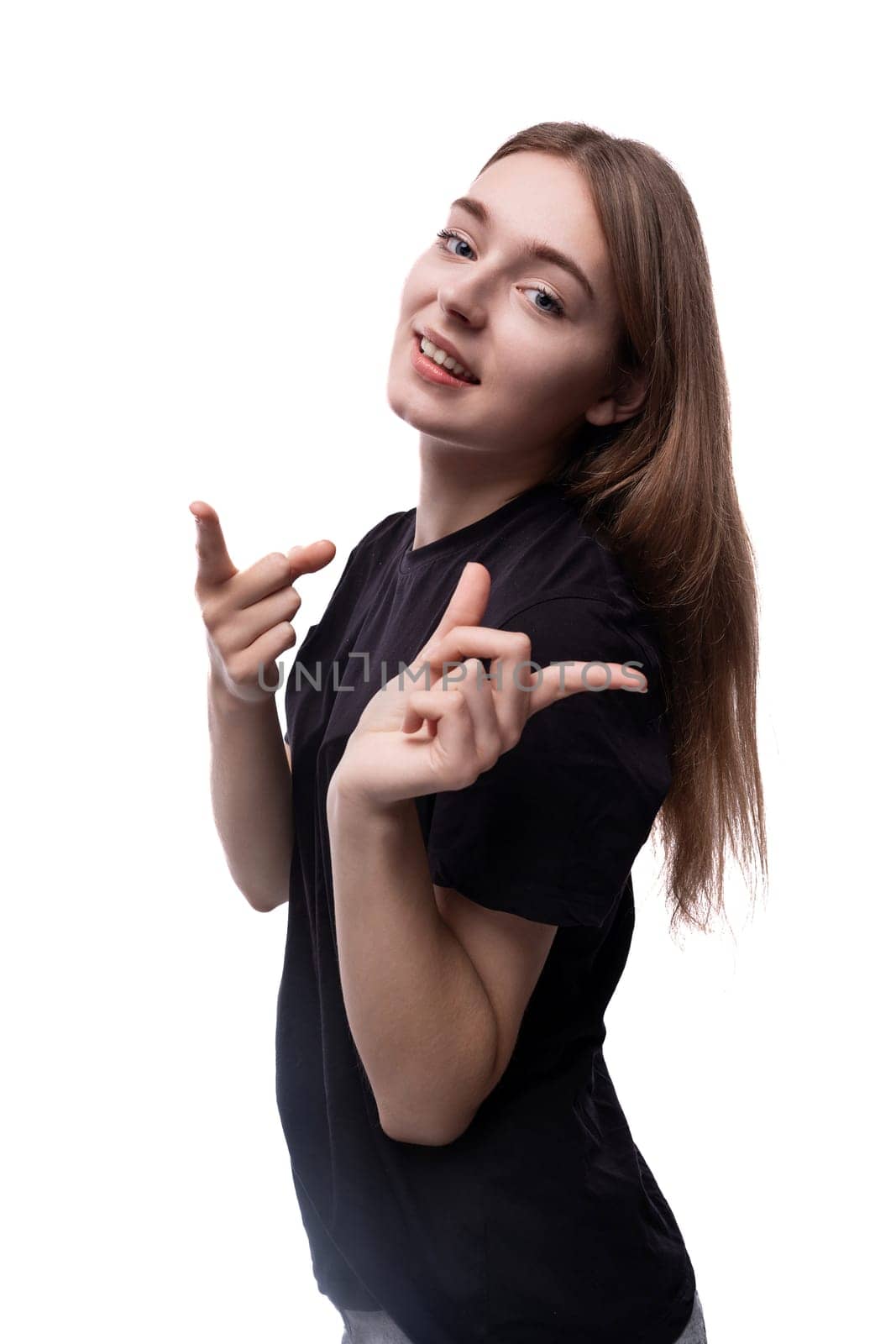 A fair-haired teenage girl in a black T-shirt shows her silky hair.