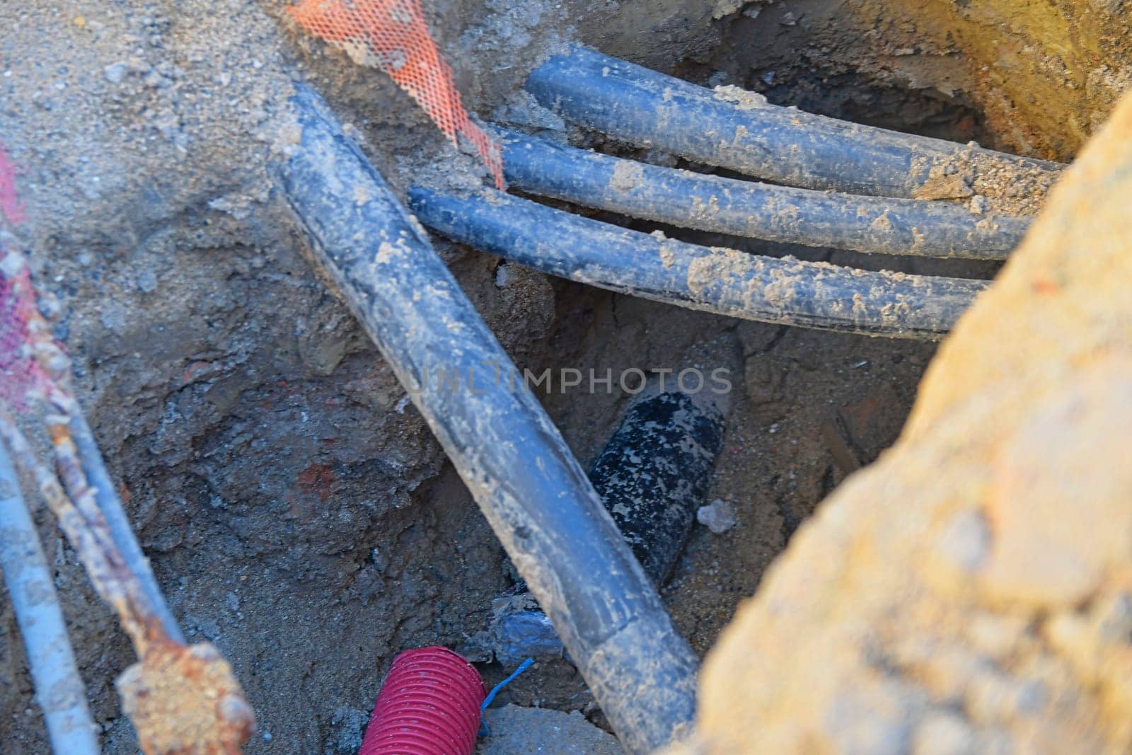 Cables in the trench. High voltage black cables in the trench. Concept of electrical installations, construction works, building renovations and building refurbishments by roman_nerud
