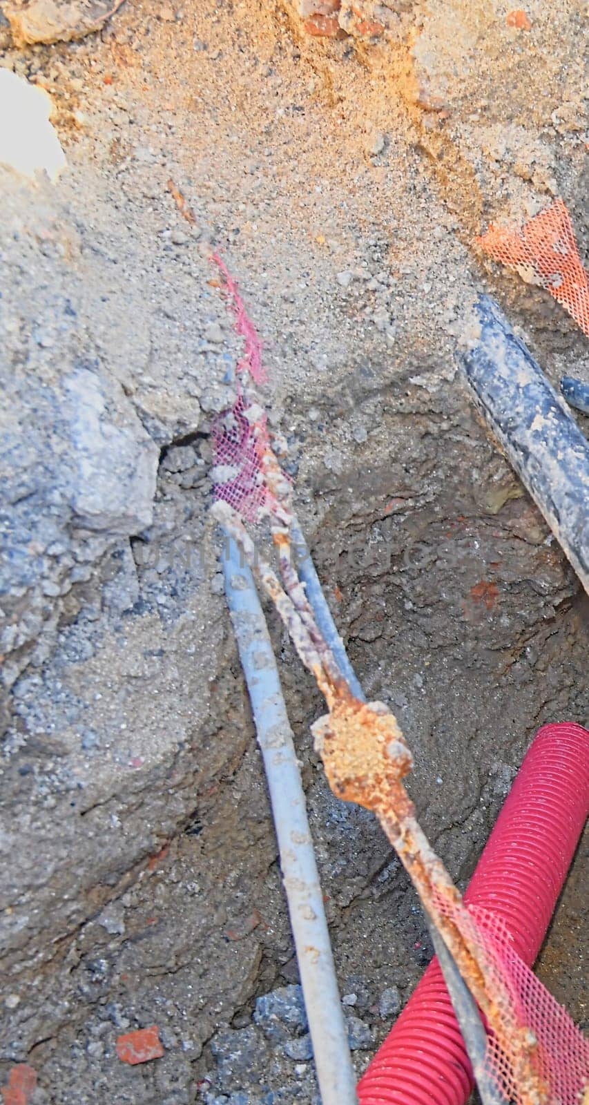 Cables in the trench. High voltage cables in protective red cover in the trench. Concept of electrical installations, construction works, building renovations and building refurbishments. by roman_nerud