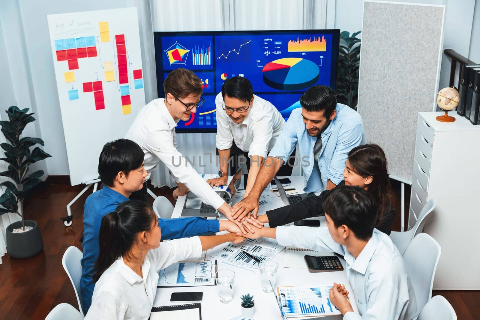 Analyst team leader celebrate with his colleague after successful data analysis meeting using FIntech software power with business intelligence or BI dashboard. Prudent