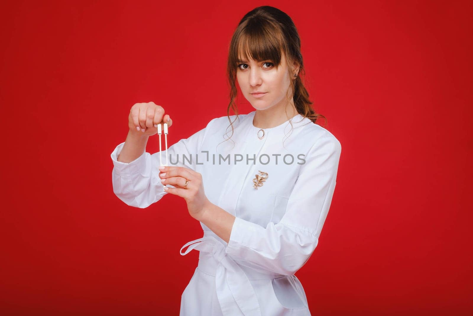 Beautiful girl doctor with a tuning fork stands by Lobachad