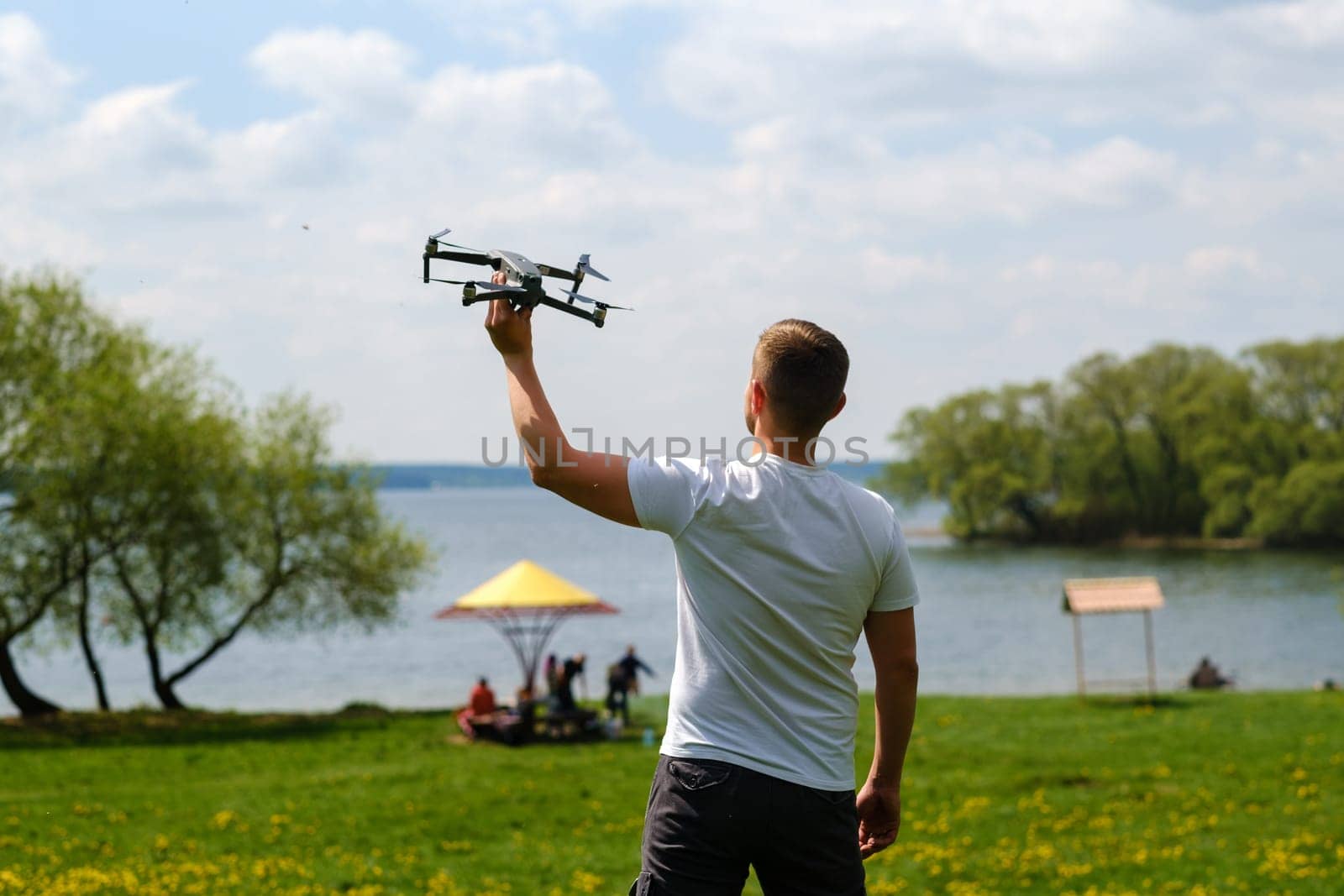 A man with a flying vehicle in his hands, raised to the sky in nature.Launching a drone.