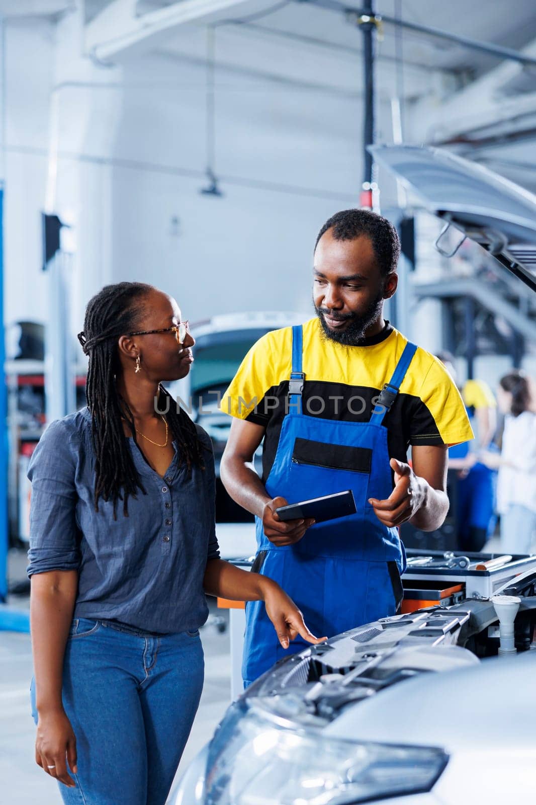 Worker informs client of car motor costs by DCStudio