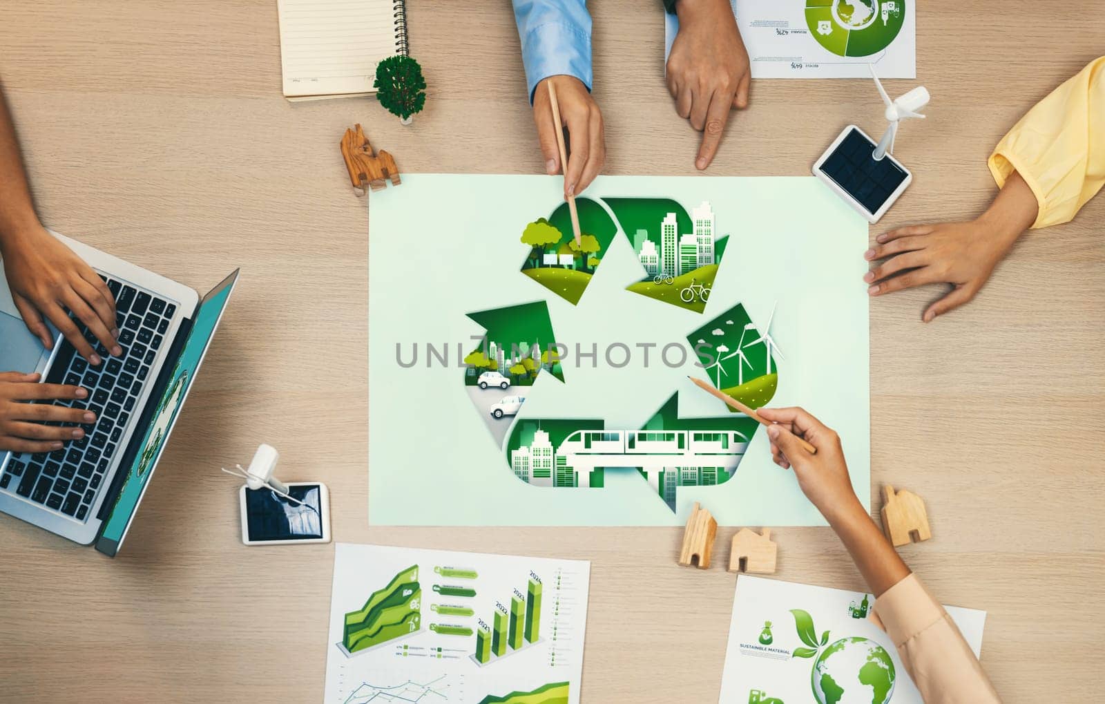 Eco city and recycle illustration placed on a meeting table during a green business meeting discussion. ESG environment social governance and Eco conservative concept. Top view. Delineation.