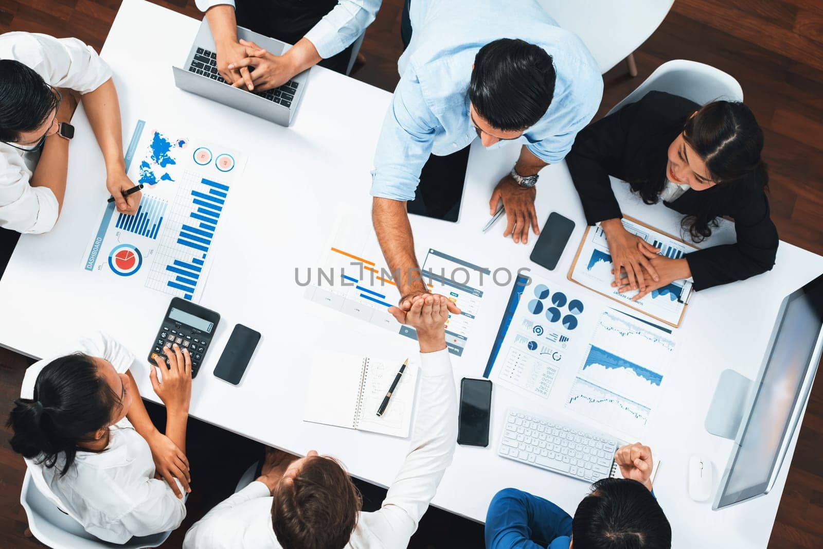 Top view diverse office employee worker high five after making agreement on strategic business marketing planning. Teamwork and positive attitude create productive and supportive workplace. Prudent