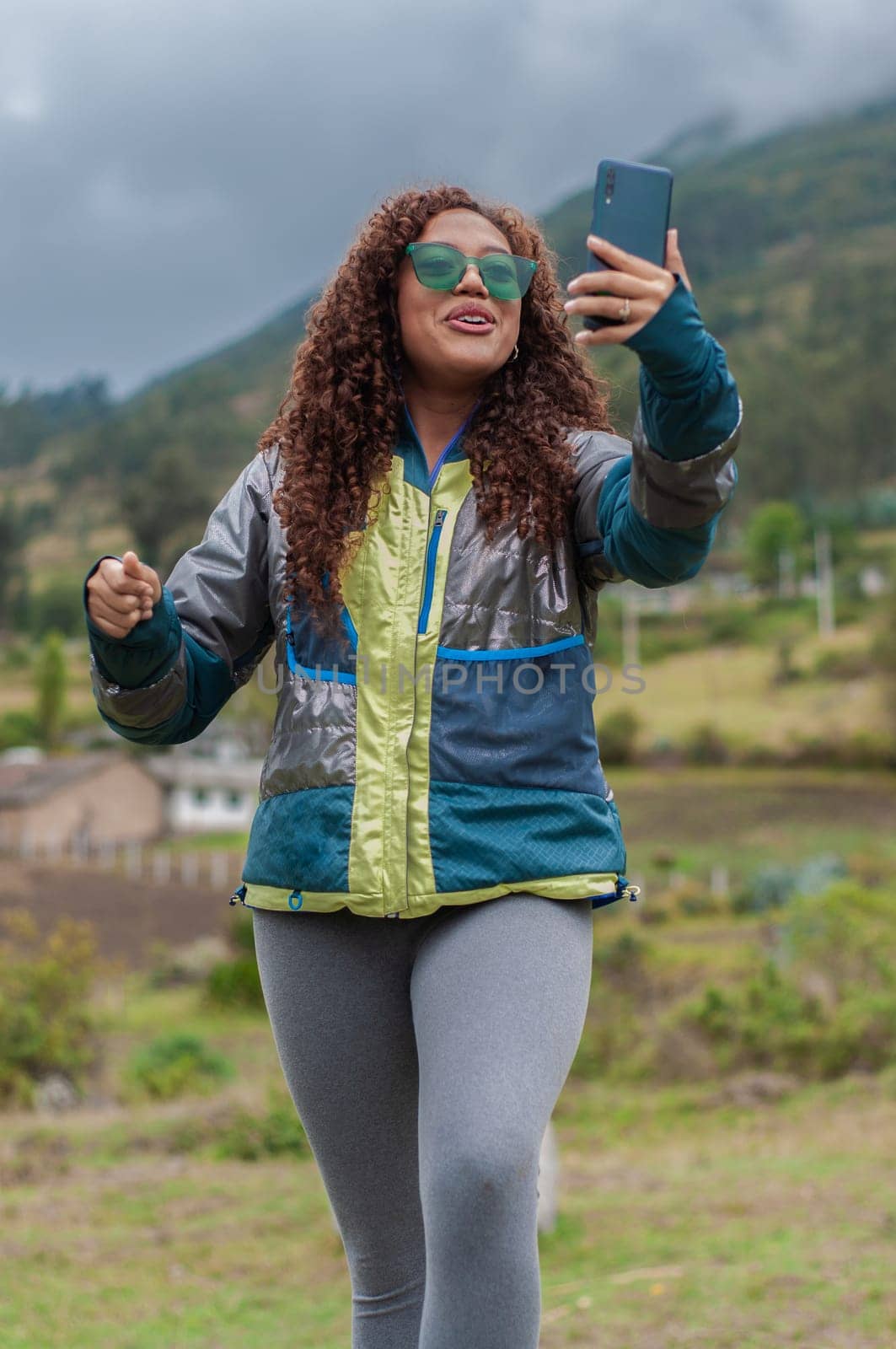 vertical photo of travel vlogger from ecuador performing a live show while talking to her followers in a rural setting. . High quality photo