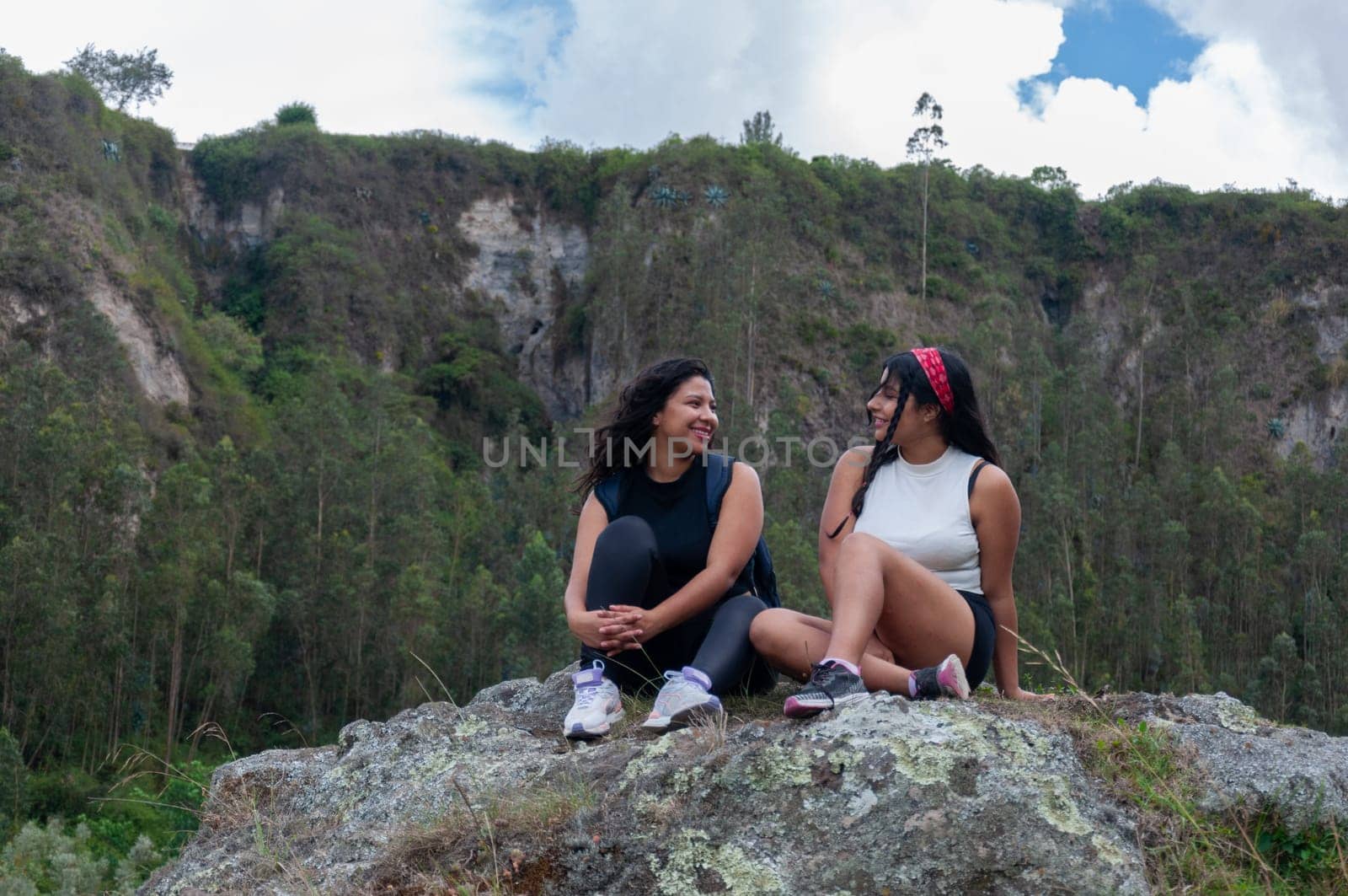 two smiling friends on top of a mountain in ecuador on their vacation enjoying rural tourism by Raulmartin