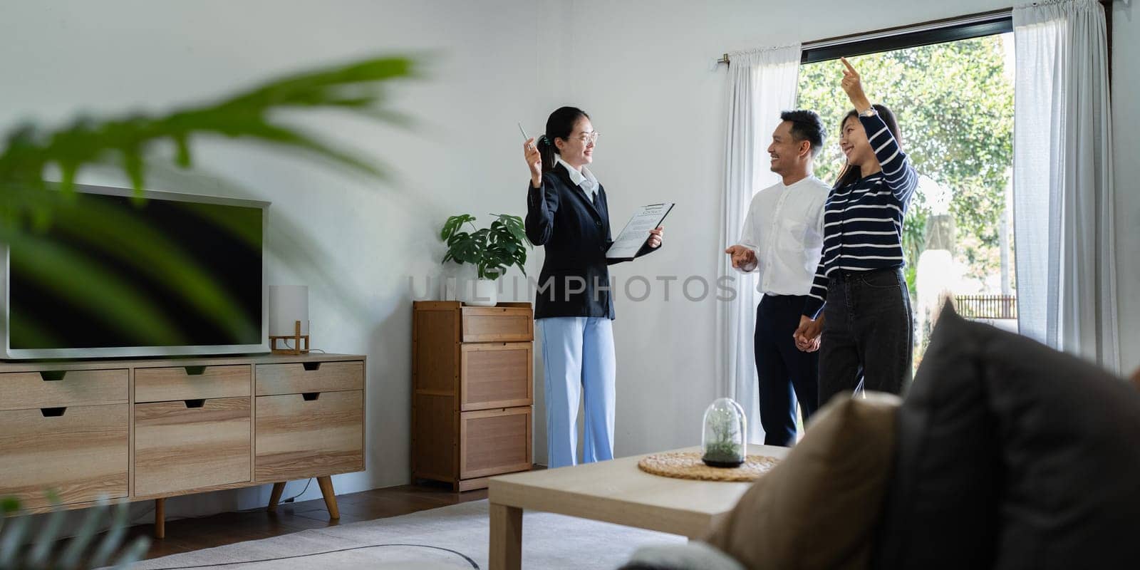 young couple with a real estate agent visiting home for buy or for rent.