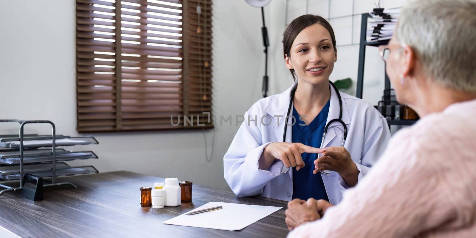 Female doctor are advice medication and vitamin daily to elderly patient.