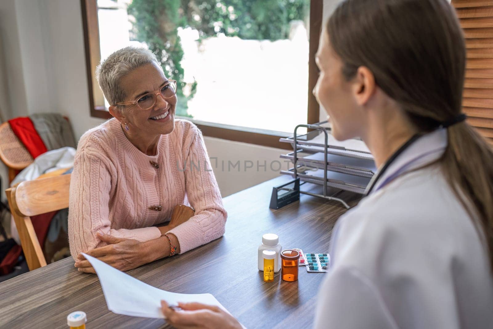 Caucasian Female doctor are advice medication and vitamin daily to caucasian elderly patient.