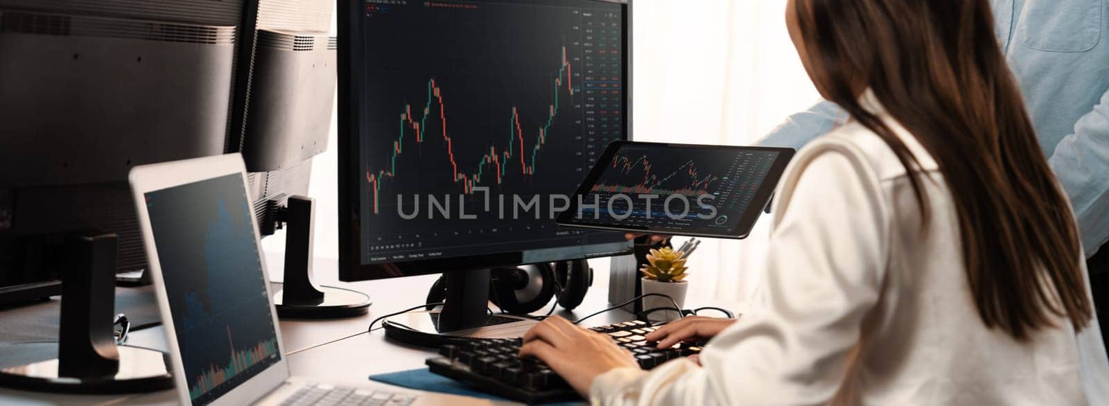 Group of traders discussing on office desk, monitoring stock market on monitor at office workplace. Businessman and broker analyzing stock graph together at stock trading company. Trailblazing