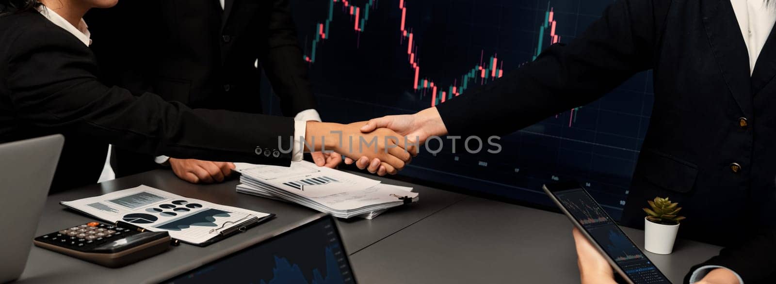 Stock investors celebrate successful profit from selling stock and shaking hand with each other, market analysis and strategic decision-making led to successful stock trading exchange. Trailblazing