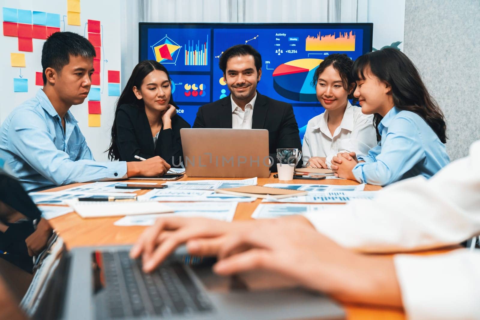 Closeup hand typing keyboard laptop with blurred background of business people using laptop to analyze financial data or data analysis display on screen background. Meticulous