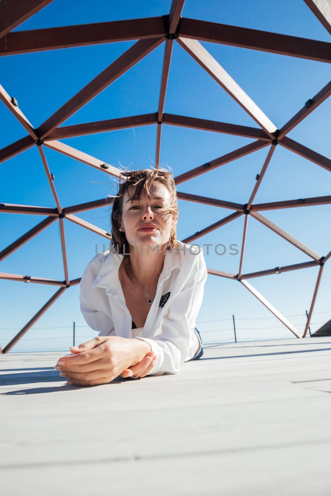 fashionable woman posing by wooden structure