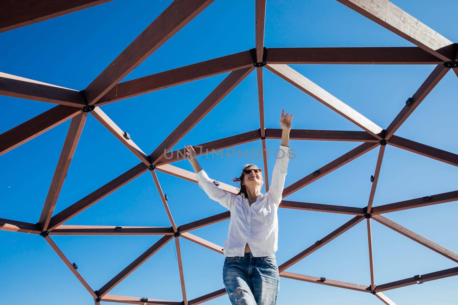 fashionable woman posing by wooden structure