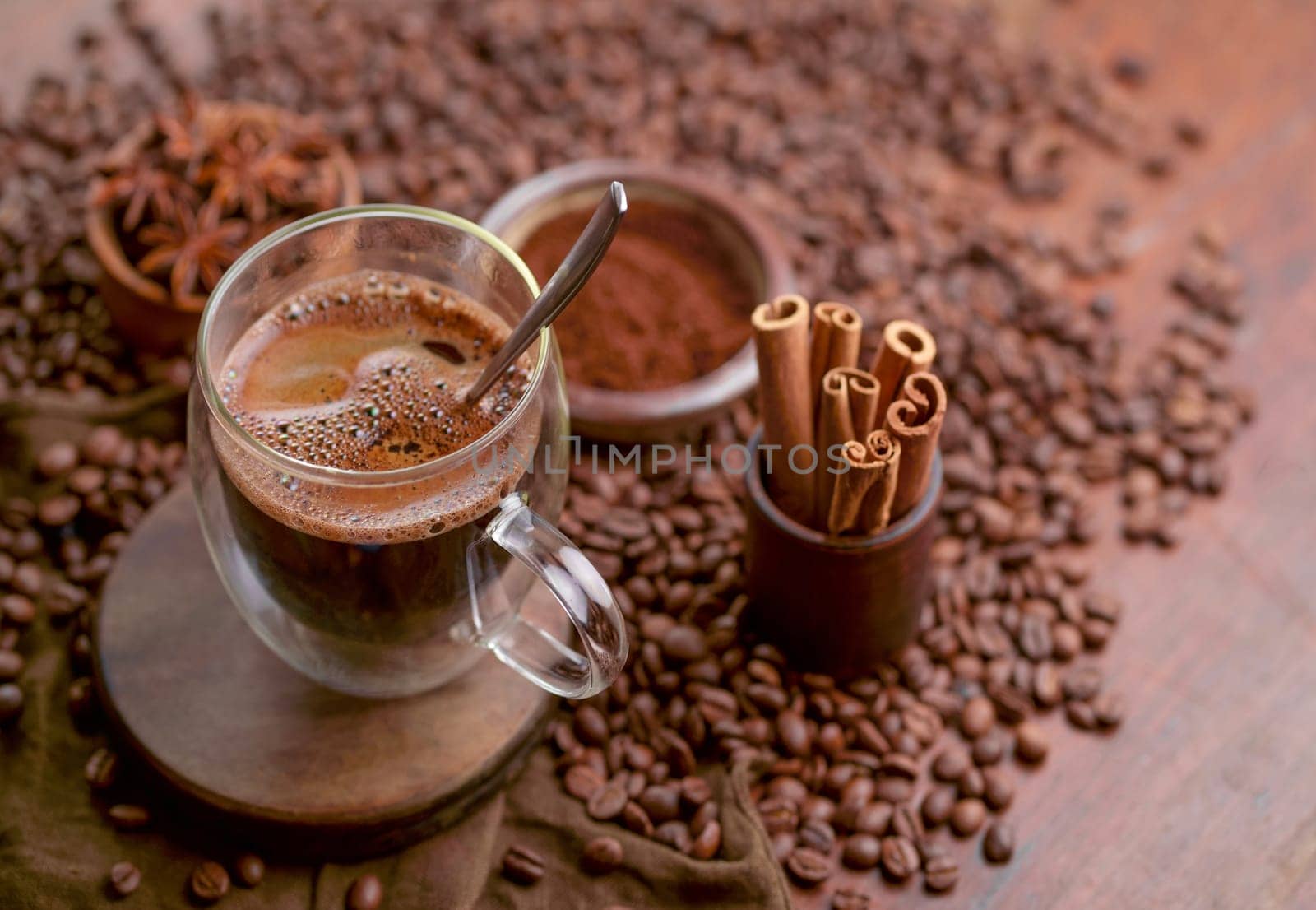 Cup glass of coffee with smoke and coffee beans on old wooden background by aprilphoto