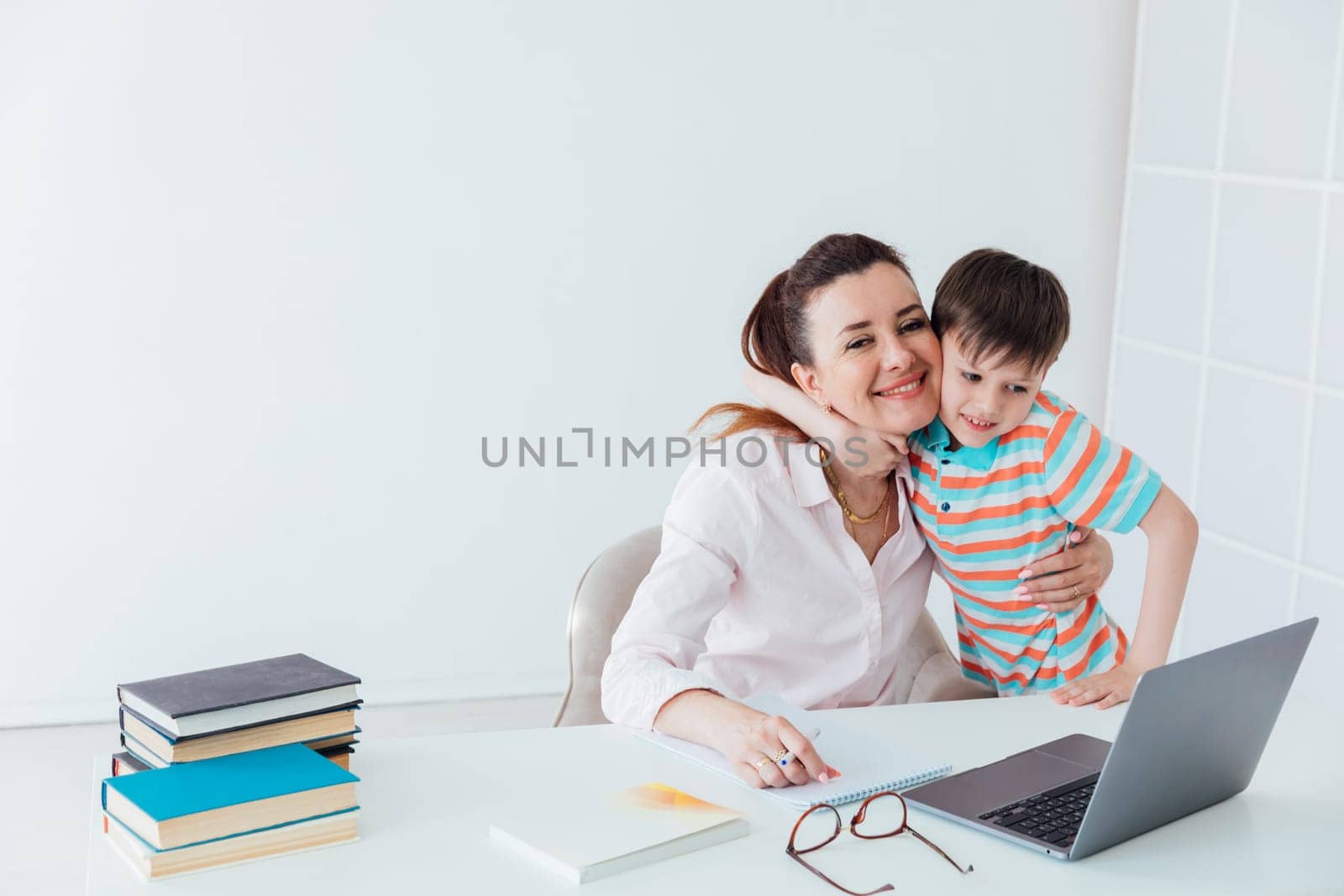 Woman with boy playing laptop online by Simakov