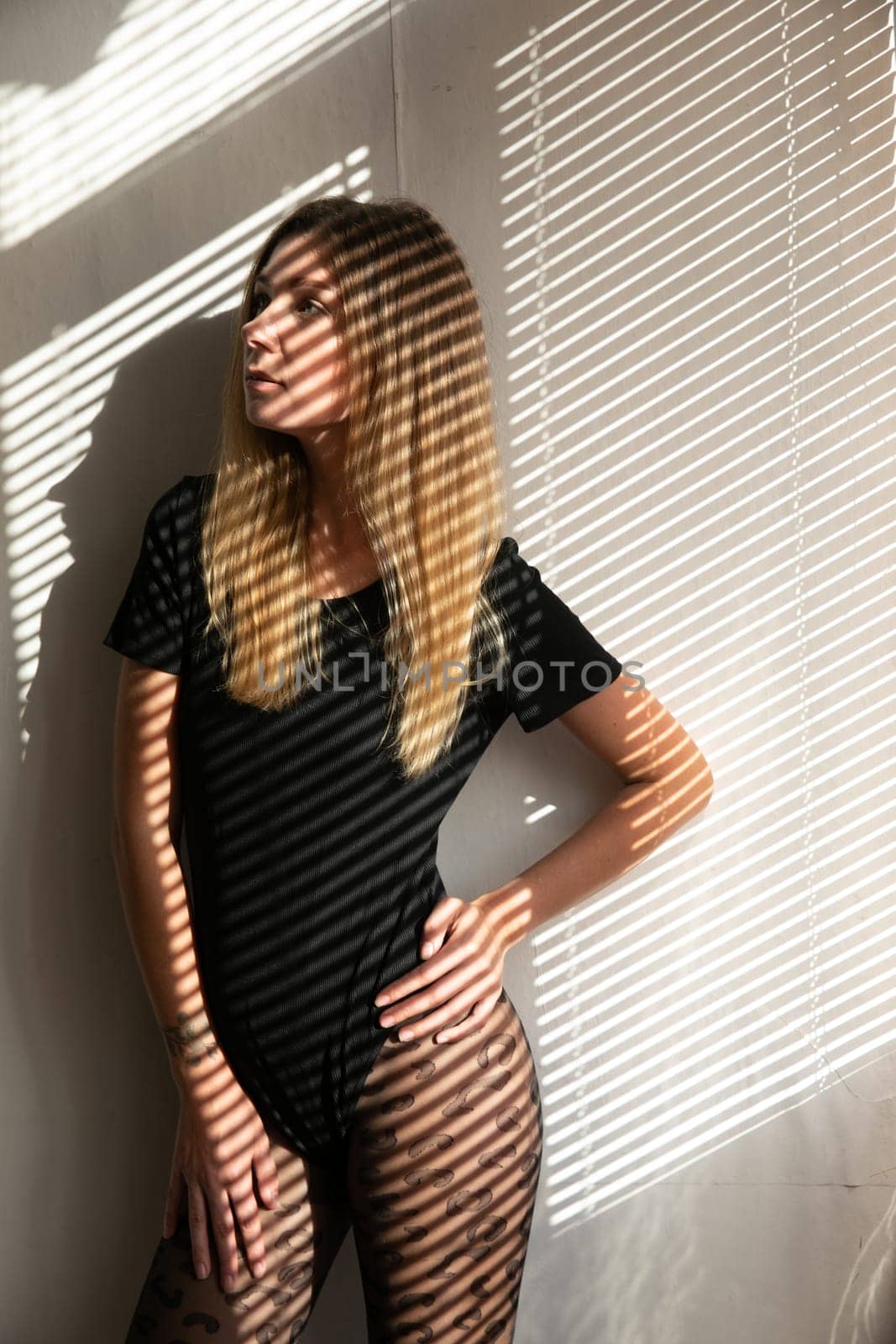 Light from blinds on woman