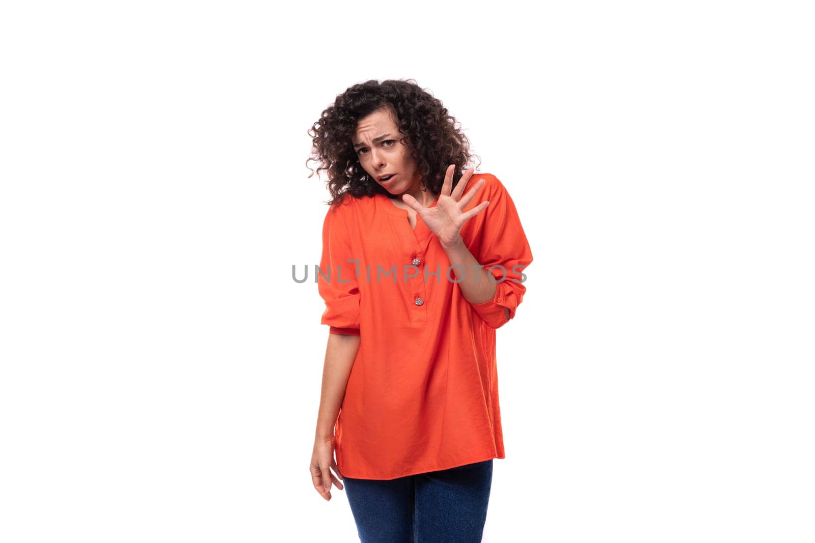 young caucasian business woman with a curly hairstyle dressed in an orange blouse shows her disagreement.