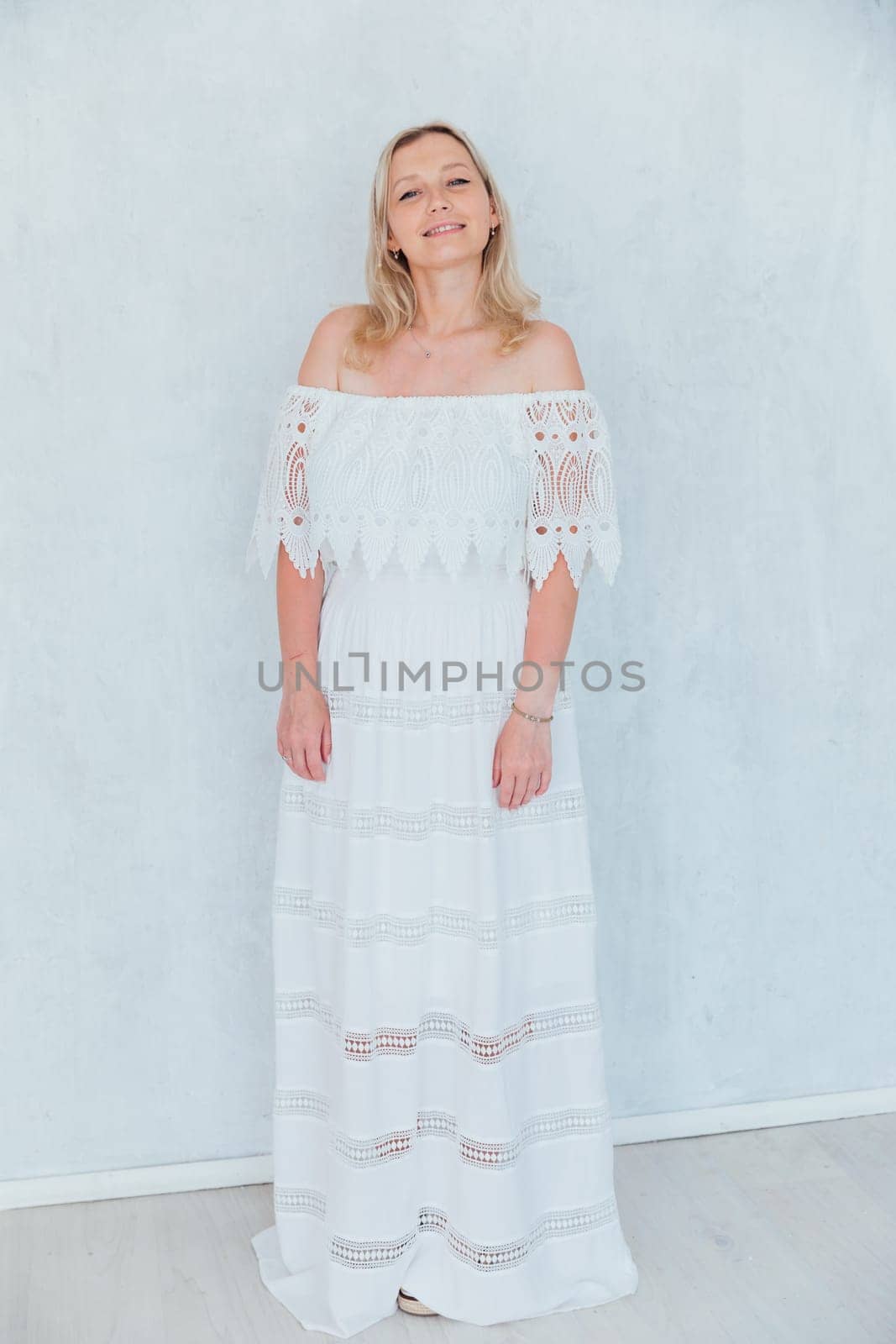 Portrait of beautiful fashionable woman in white smile dress