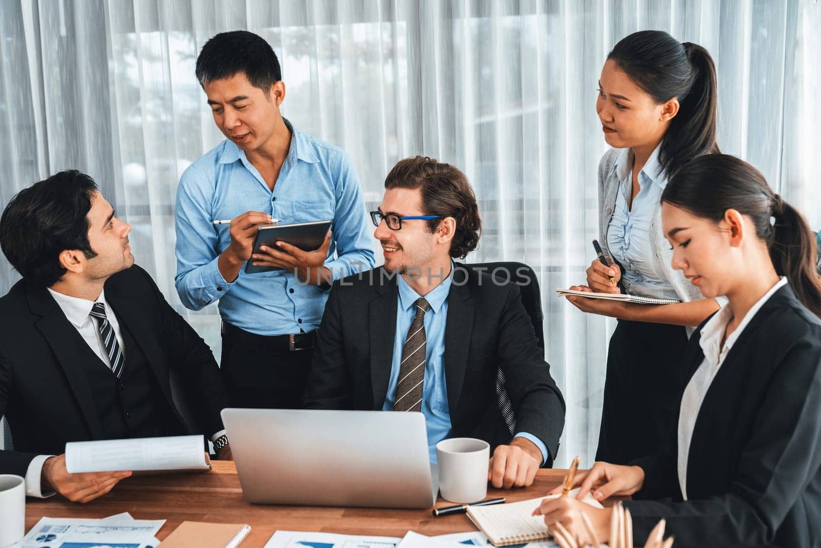 Diverse of business people from various ethnic group working in modern office environment. Productive and multi ethnic office workers engage in discussion for strategic business marketing. Meticulous