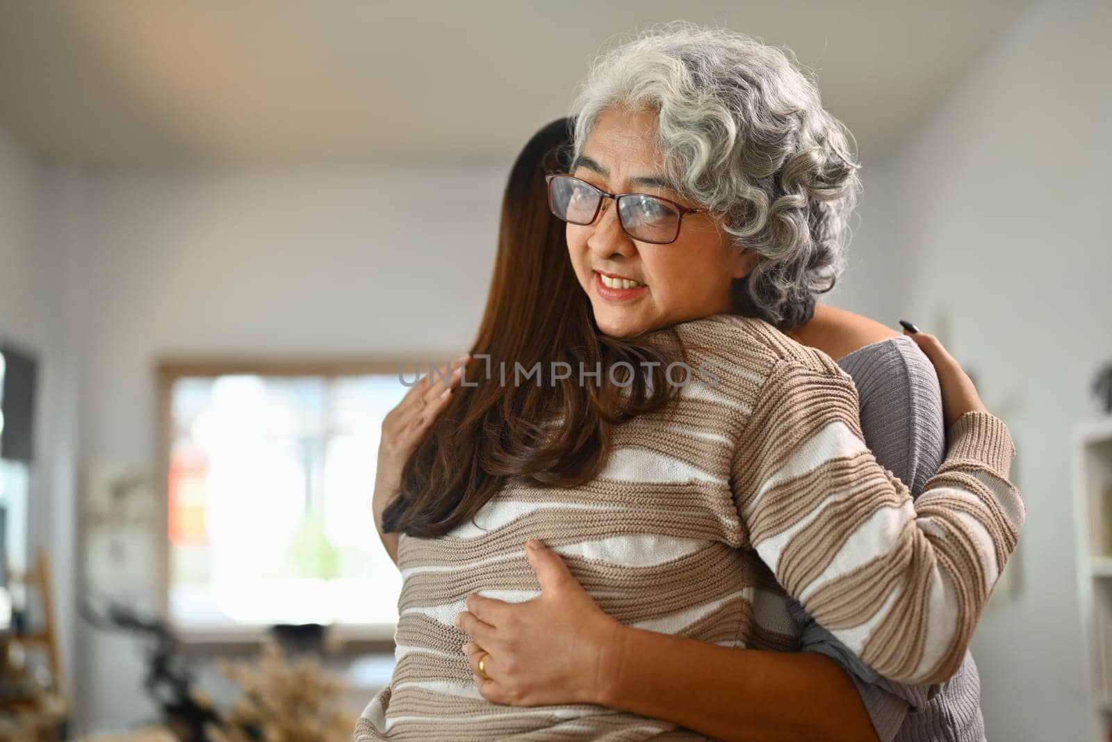 Sweet moment of middle aged mother hugging her loving daughter, expressing unconditional love.