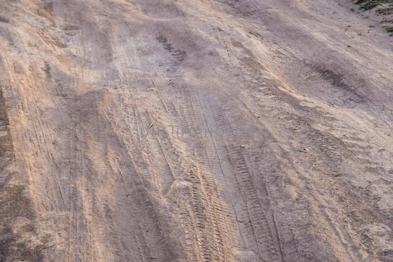 dusty dirt road at summer day, full-frame closeup view.