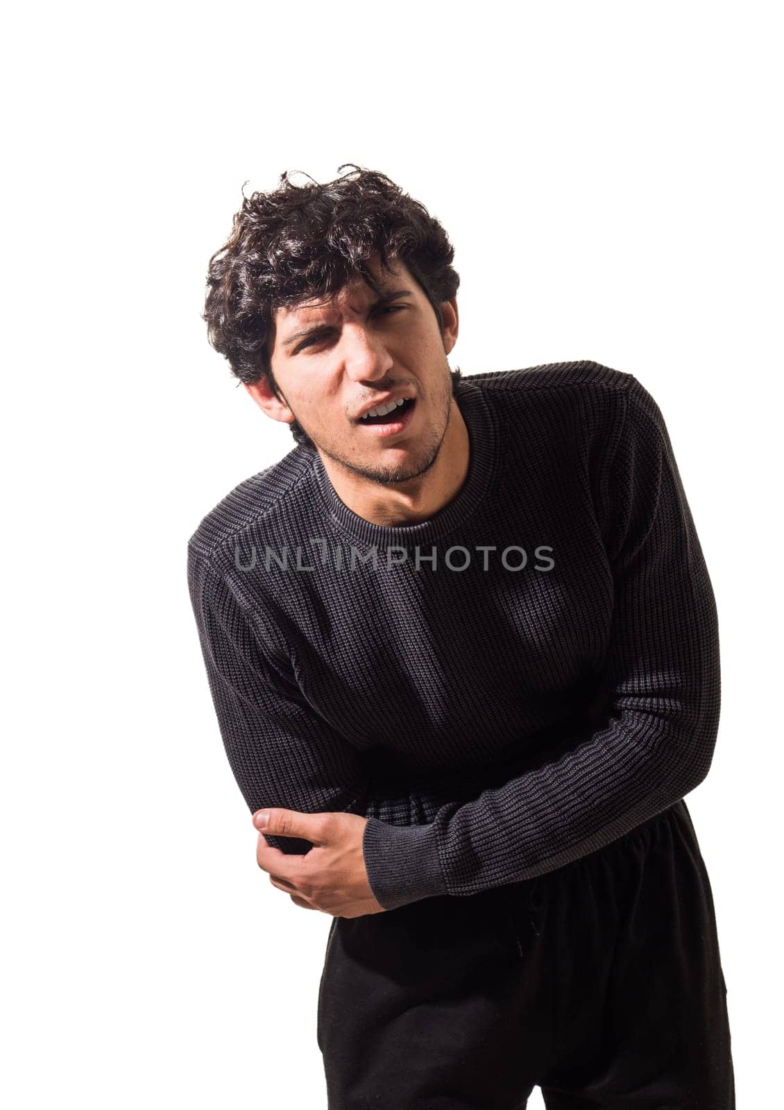 A young man is suffering from belly-ache, stomach ache, in a black sweater and black pants