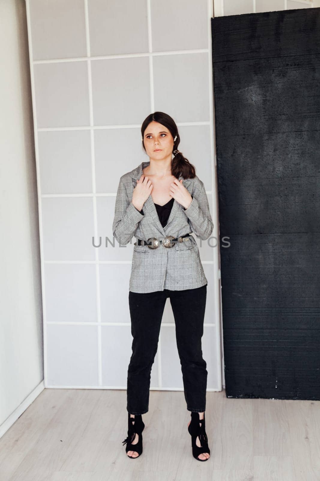 Fashionable woman posing in bright room in studio