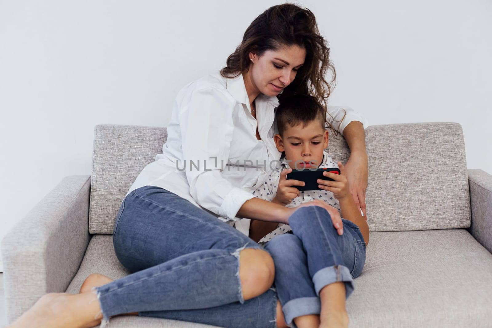 Mom with son resting at home on the couch white