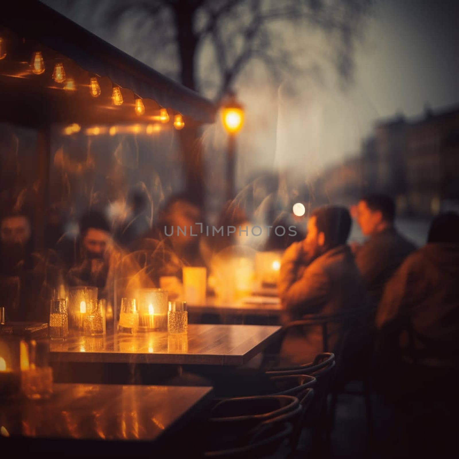 Blurred image of a street cafe or bar in the light of evening lights. In summer people sit at cafe tables.