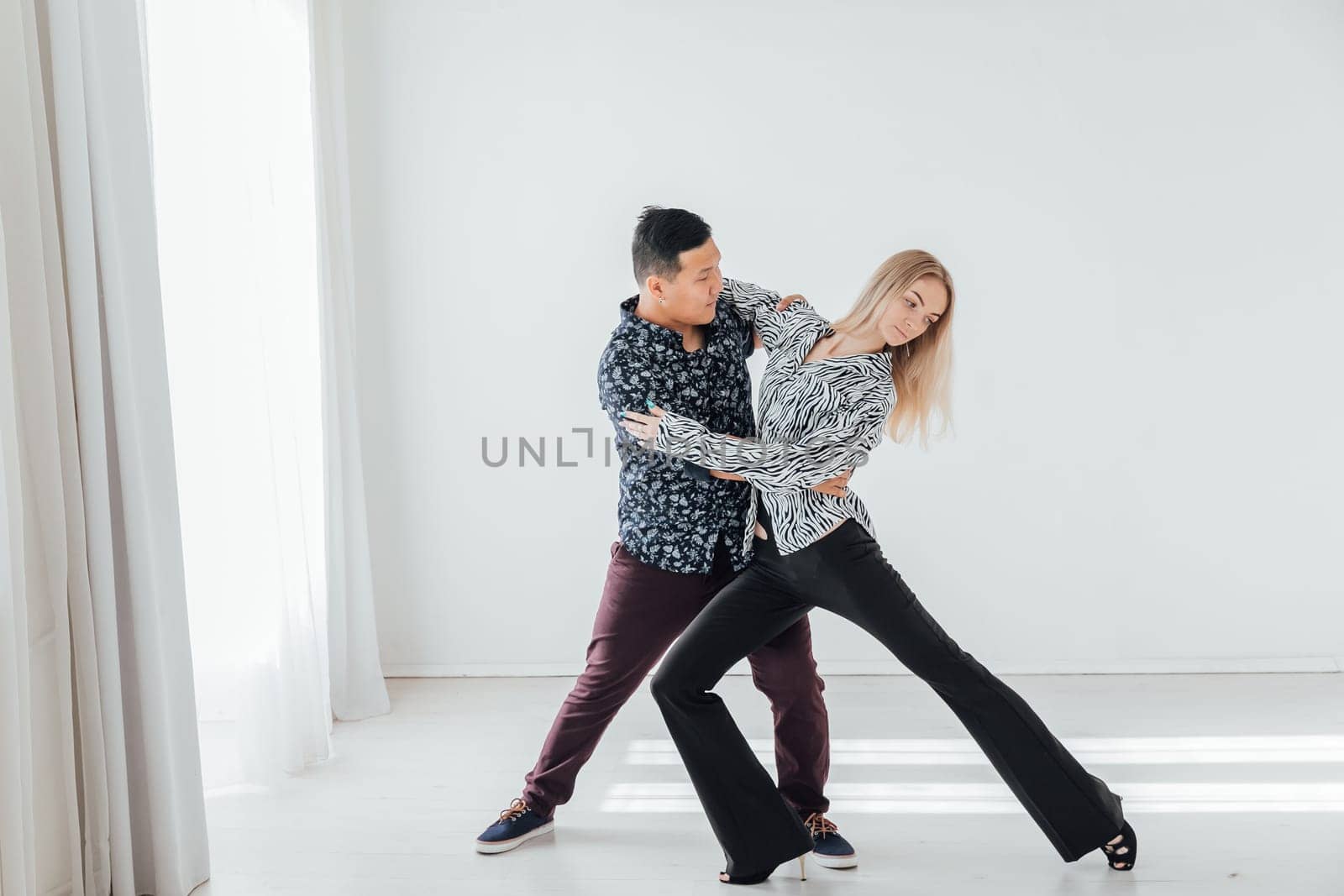 A man and a woman dancing in a coach's studio by Simakov