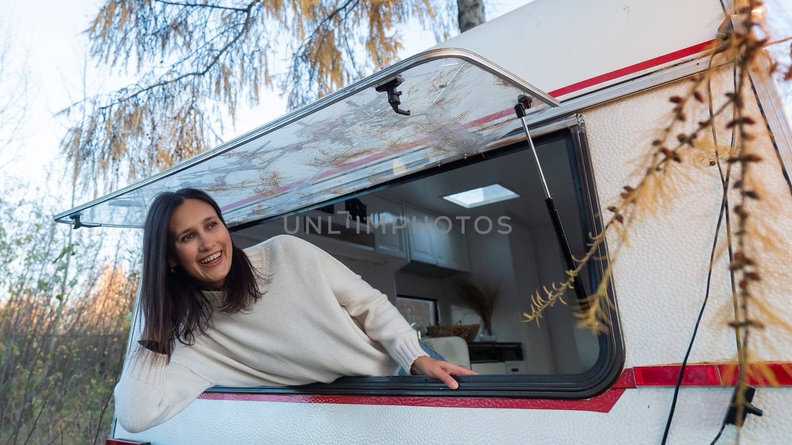 Caucasian woman peeking out of camper window. by mrwed54
