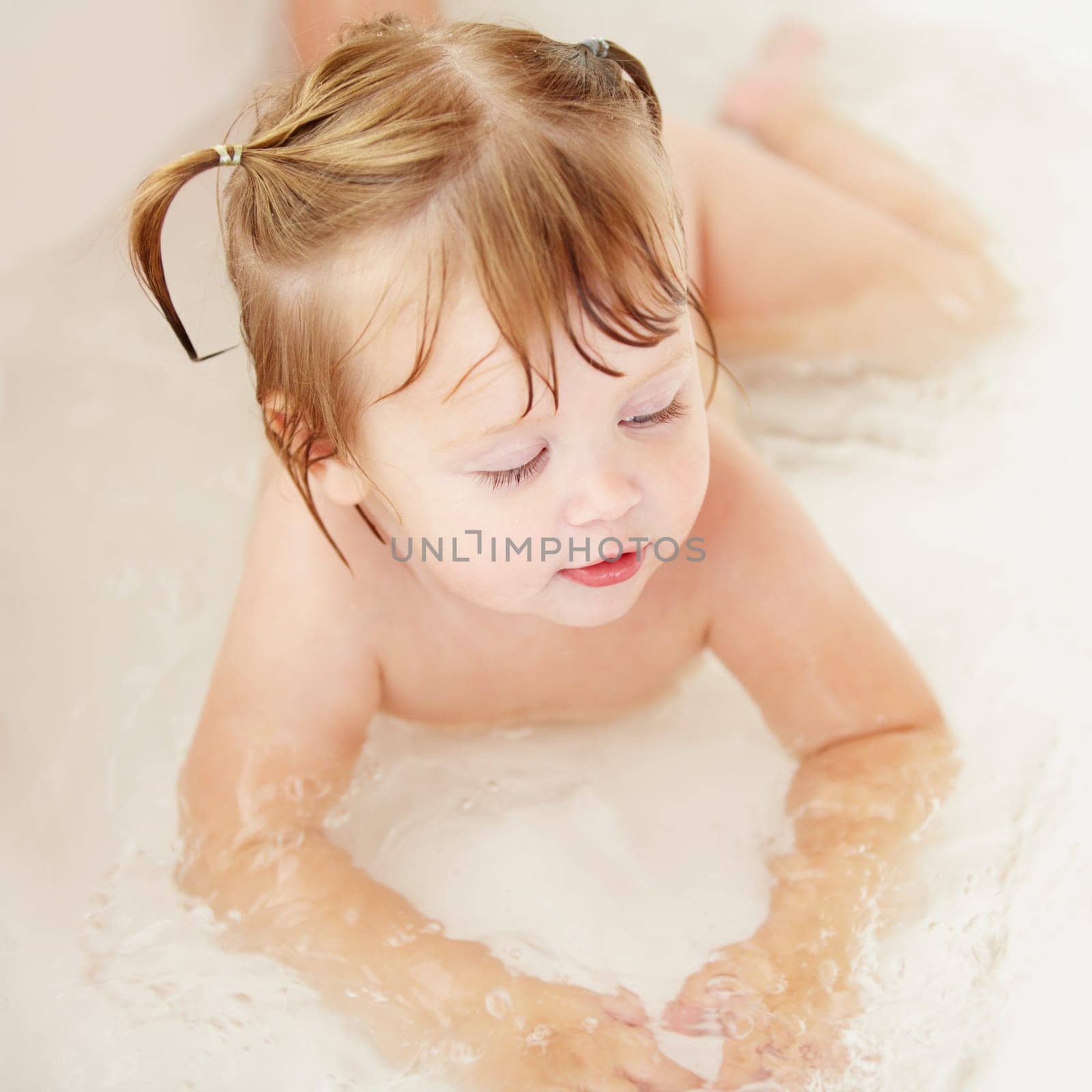 Children, cleaning and water with a baby in the bath for natural skincare, development or hygiene. Kids, bathroom and a happy young toddler girl in a bathtub for health and wellness in her home by YuriArcurs