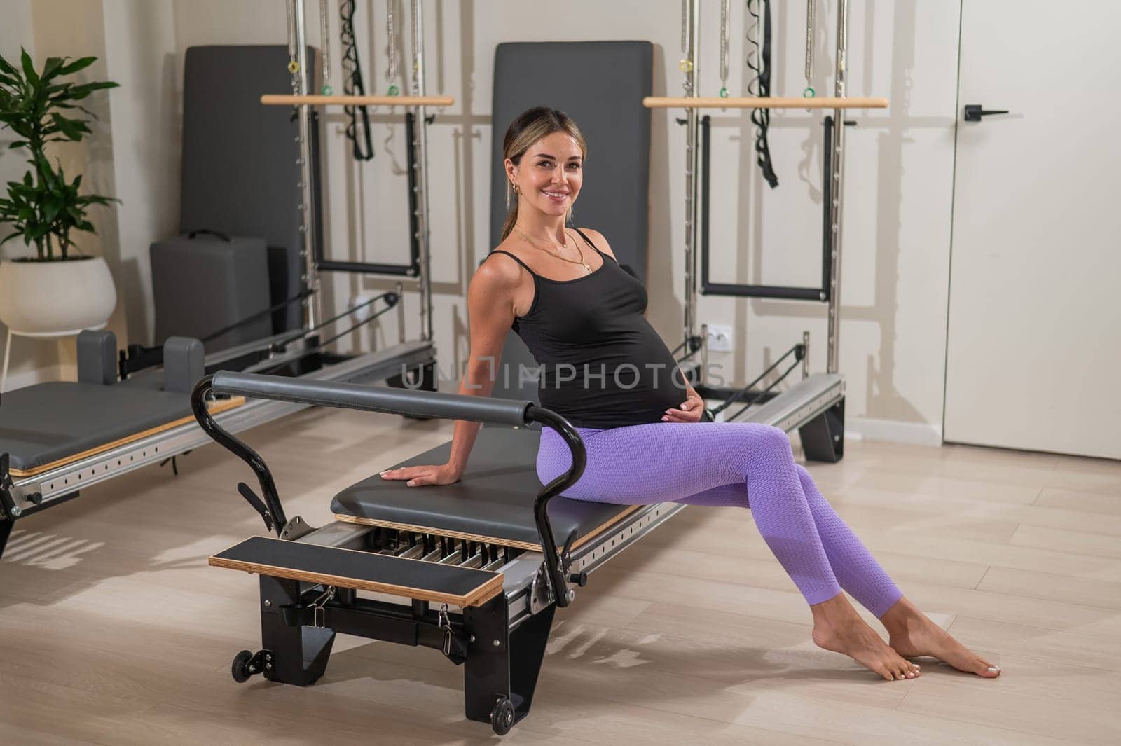Pregnant woman resting after Pilates on a reformer machine. by mrwed54