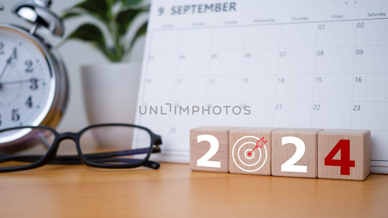 Wooden blocks with letters 2024 with calendar and alarm clock on wooden background representing the transition to 2024, Business Startup plan, The countdown begins to 2024, defining the future calendar strategy. by Unimages2527