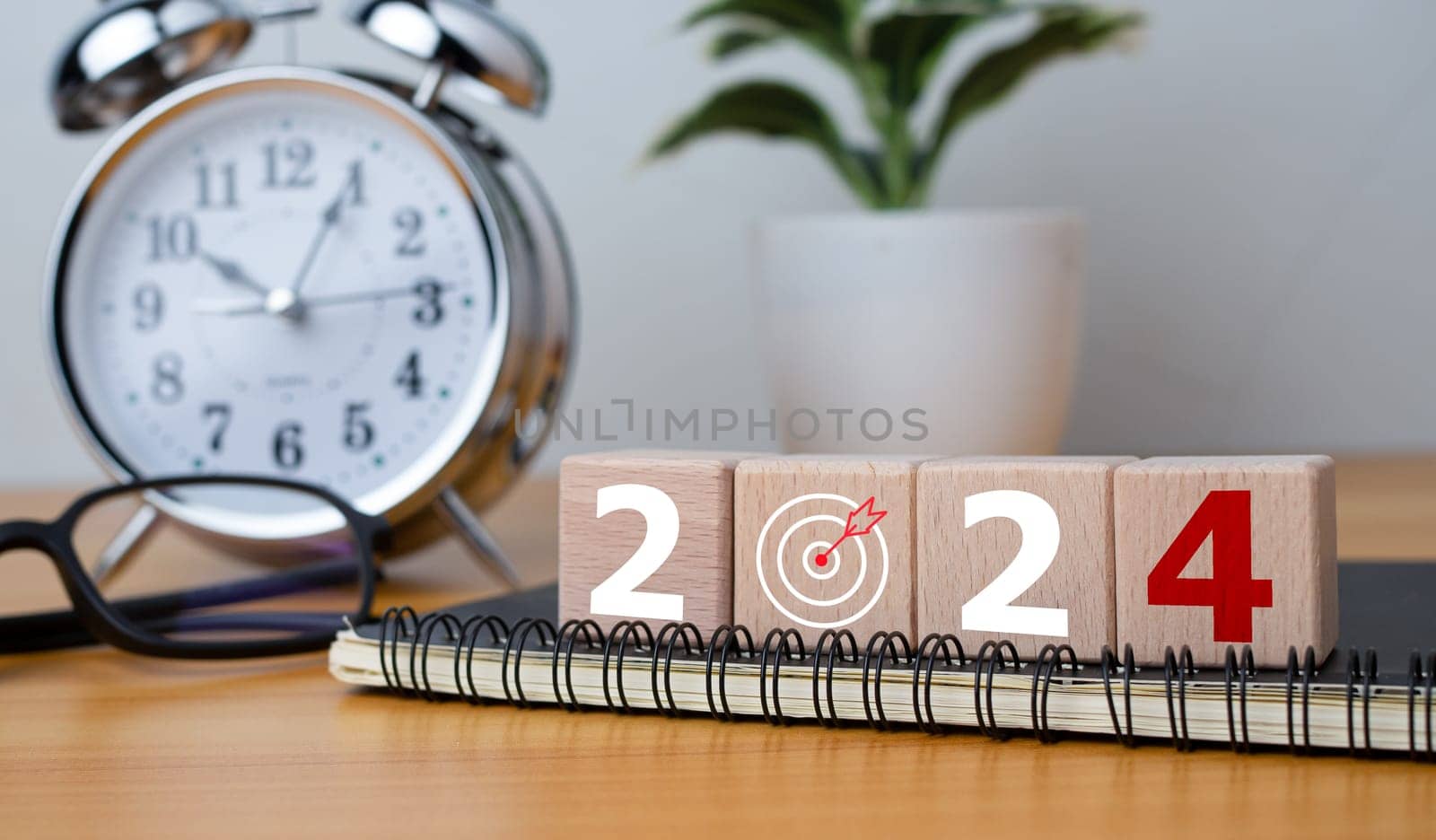 Wooden blocks with letters 2024 with calendar and alarm clock on wooden background representing the transition to 2024, Business Startup plan, The countdown begins to 2024, defining the future calendar strategy. by Unimages2527