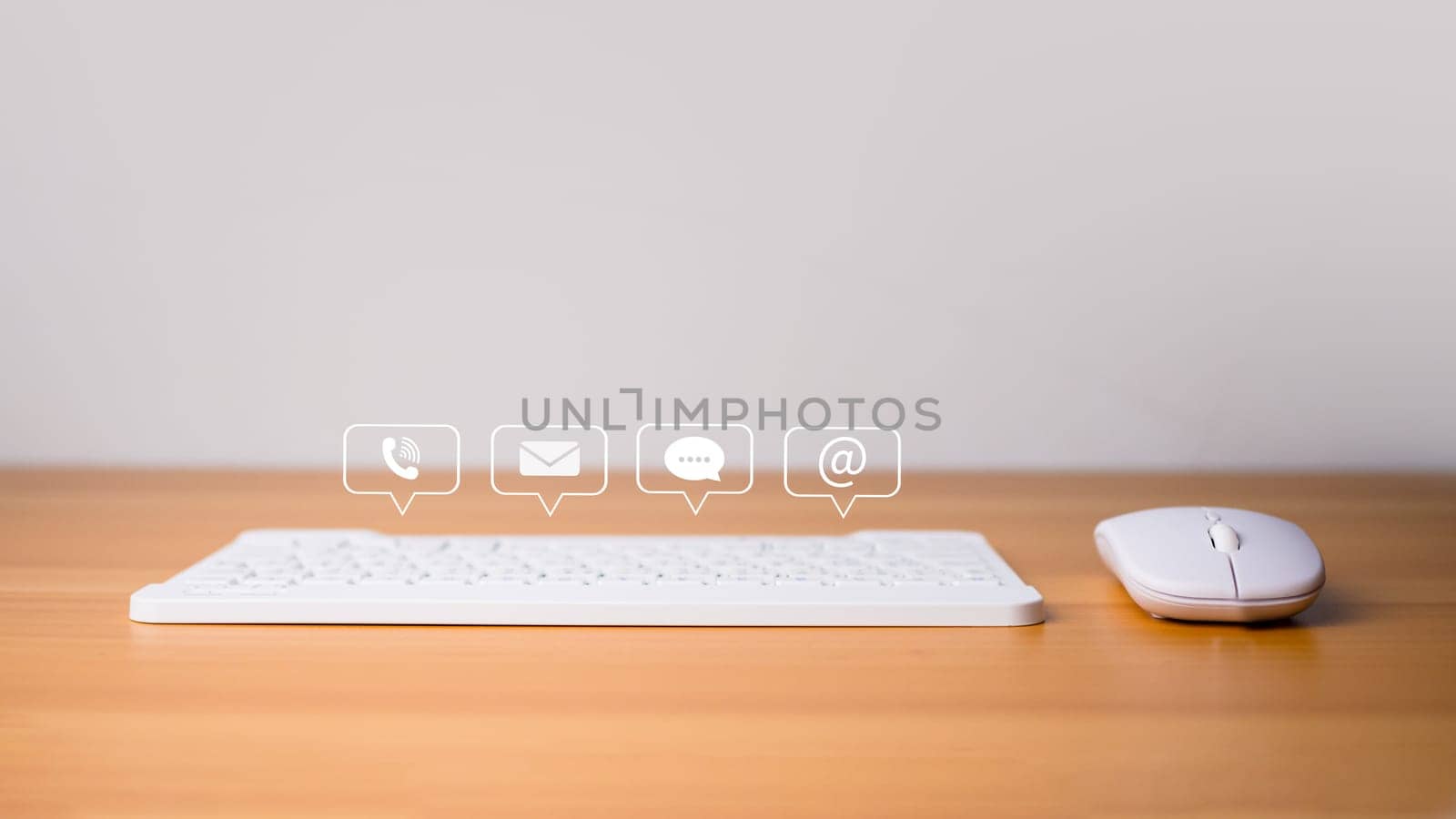 Contact us website page or email marketing concept, customer support hotline, contact us, Keyboard and mouse placed on wooden background with email icons, phone, address, chat message. by Unimages2527