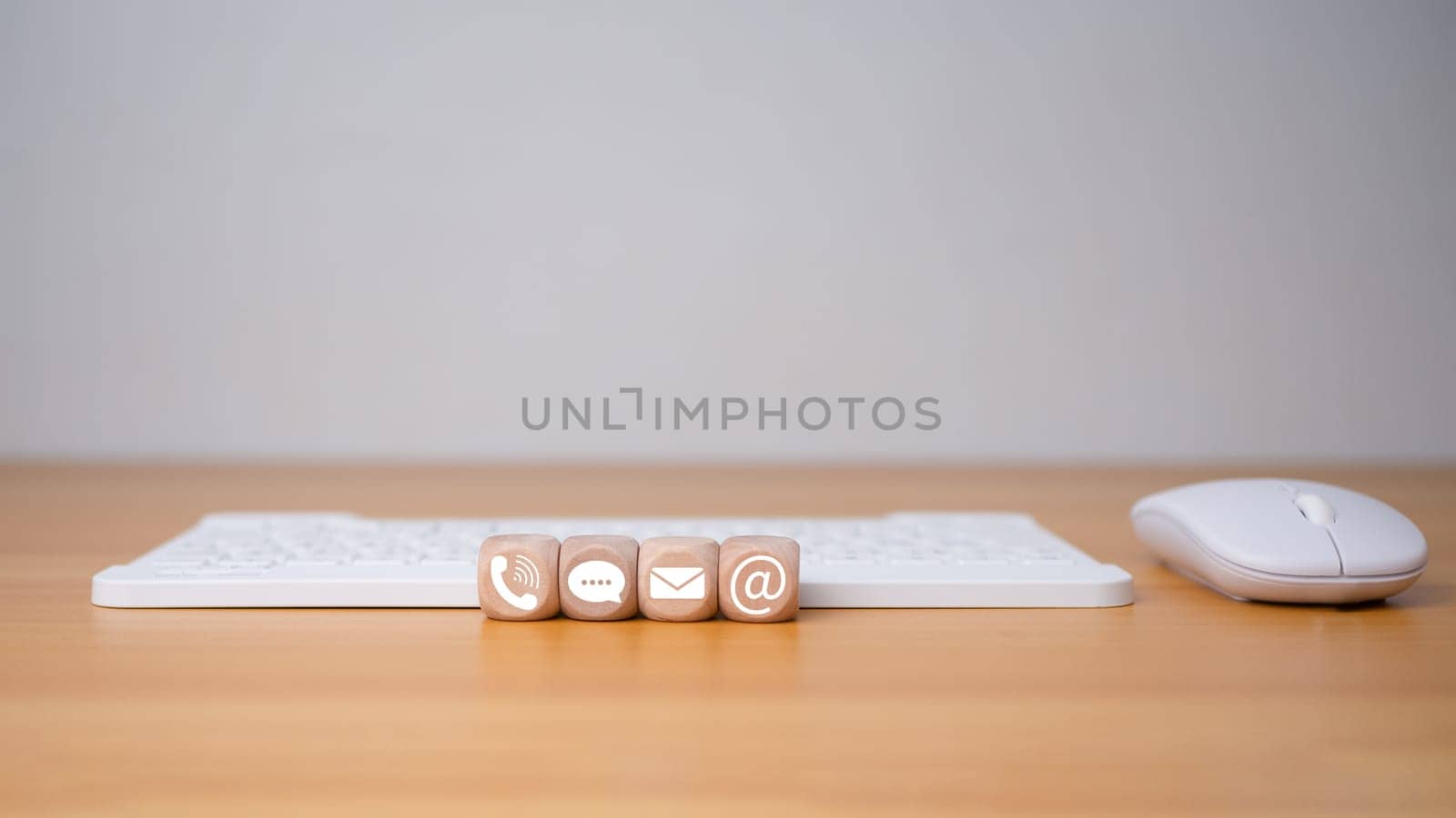 Contact us website page or email marketing concept, customer support hotline, contact us, Keyboard and mouse placed on wooden background with email icons, phone, address, chat message. by Unimages2527