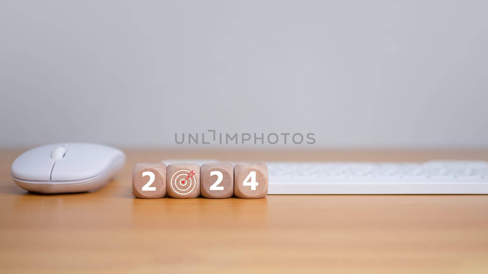 Wooden blocks line the wooden floor and bear the letters 2024, representing the setting of goals for 2024, the idea of a startup. Financial planning, development, business strategy Setting business goals by Unimages2527