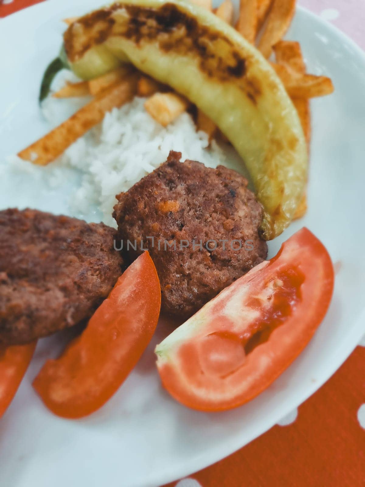 Turkish lunch, meat cutlets, rice and grilled vegetables, soft focus. by Leoschka