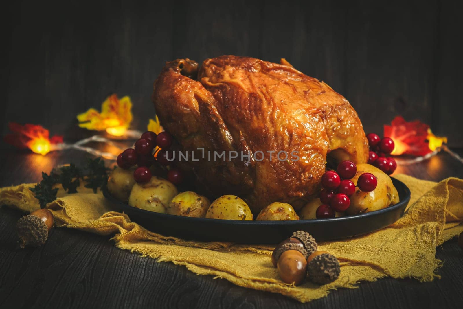 Chicken with potatoes in a dish on a yellow kitchen napkin, garland leaves and acorns. by Nataliya